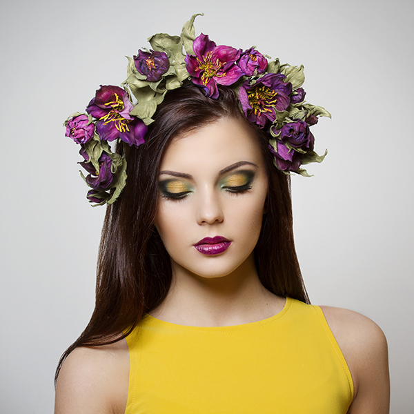 beautiful young woman with bright makeup wearing floral headband